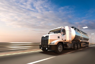 A truck driving down a highway for a Gasoline Delivery for East Peoria IL