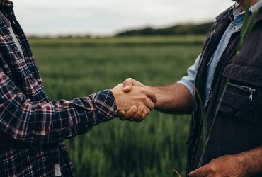 A farmer and delivery person shake hands after the farmer received Propane Delivery in Eureka IL