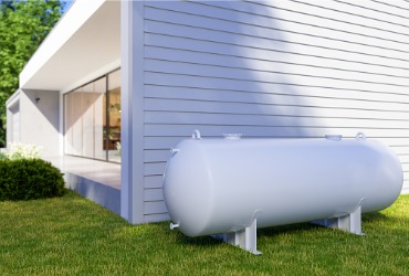 White propane tank sitting next to a house from a propane company in McLean County IL.